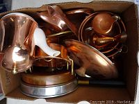 Image showing a variety of copper kitchen items including pots, a kettle, and pans in a box.