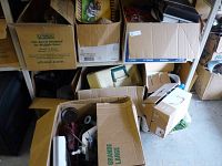Multiple cardboard boxes arranged with various items inside, showing a mix of household and decorative items.