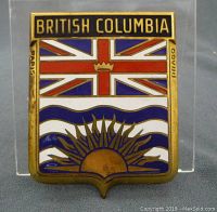 Front view of the full badge showing the British Columbia flag design with brass frame and enamel colors.