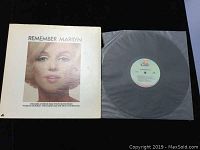 White outer sleeve with a close-up photo of Marilyn Monroe on the front and vinyl record partially visible inside clear plastic sleeve.