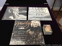 Overview of three Marilyn Monroe calendars from years 2002, 2004, and 2005, all sealed, alongside a box of Marilyn Monroe collector cards.
