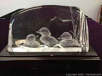 Full view of clear rectangular crystal sculpture with three ducks in water on black wooden stand, showing overall condition and base.