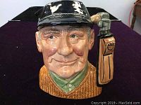 Front view of the Royal Doulton Toby Jug showing the golfer's detailed face and black cap
