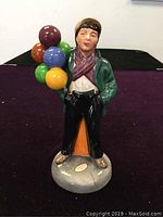 Front view of the Royal Doulton figurine showing the boy holding colorful balloons