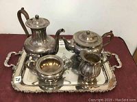 Overall view of vintage silver plated tea service on tray, including teapot, coffee pot, creamer and sugar bowl