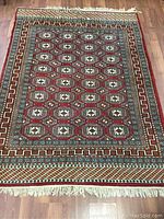 Full view of the Persian style wool rug on wooden floor showing overall pattern and edges