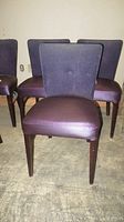 Front view of three purplish plum dining chairs with fabric backs and satin-look leatherette seats.