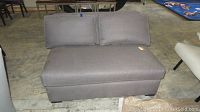 Front view of the grey upholstered loveseat showing two back cushions and seat