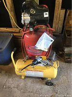 Front view showing red King Canada compressor and yellow Power Fist compressor with attached hoses.