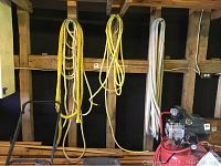 Photo showing three pegs with multiple ropes hanging, yellow ropes on left and center pegs and white ropes on right peg, with some machinery at bottom right.
