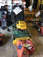 Overview of Yard-Man mower with front vacuum attachment and rear fabric grass catcher bag