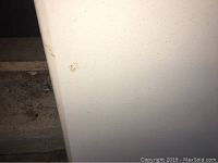 Close-up photo of table surface showing minor dirt and small stain marks.