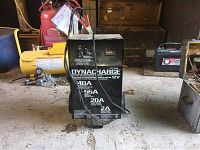 Front view of the black Dynacharger DY-1420 battery charger showing the label with charge rates and attached cables.