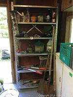 Shelf with garden supplies including bird feeders, insect spray, turf builder bucket, and other garden care items