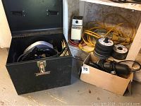 Black metal toolbox opened showing Craftsman circular saw and some tools
