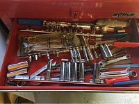 Top drawer photo showing multiple socket ratchet sets and handles within a Waterloo branded red metal tool chest drawer.