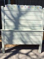 Full view of the solid wood headboard painted white with horizontal panel boards and legs.