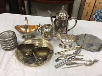Photo showing entire collection of silverplate tea set items, trays, bowls, cutlery, and related tableware pieces.