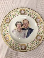 Full view of the Royal Doulton limited edition plate featuring floral and gold decorative border and central portrait of Queen Elizabeth II and Prince Philip.