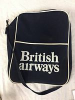 Front view of navy blue British Airways travel bag with white piping and large white logo.