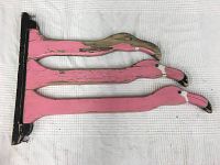 Wooden drying rack with three pink flamingo shaped slats on a black frame, showing worn paint.