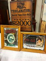 Photo showing close detail of the proclamation poster and the two advertising mirrors framed in wood.