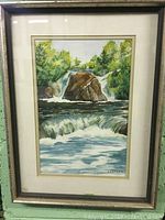 Full view of framed watercolour painting showing waterfall landscape with trees and rocks.