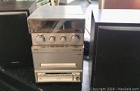 Front view of Panasonic CD stereo system with two speakers, showing control knobs and cassette/CD slots.