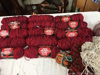 14 skeins of variegated Red Heart Super Saver yarn mainly in red and one multicolor skein