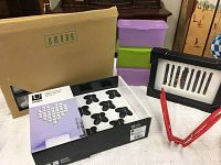 Photo of boxed Umbra Cross Stitch Wall Decor with black butterfly pieces laid out and surrounding decor items.