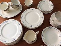 Multiple vintage Alfred Meakin 'Orient' dishes displayed on table including plates, cups, saucers, and a pitcher.