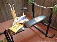 Full view of York 7500 bench, CCM stationary bike, and Bill Pearl book on bench