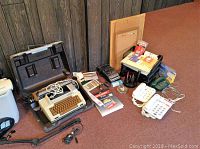 Overview of Smith Corona Coronamatic 2200 typewriter in case with two paper shredders, three home phones, three cork boards, and task lamp.