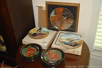 Full lot showing framed Battle of Britain plate, two train plates on boxes, and two smaller decorative plates on wooden bases
