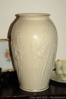 Cream-colored embossed floral Lenox vase with gold trim visible