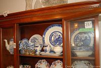 Shelf display of Willow pattern plate, teapot, creamer, sugar bowl