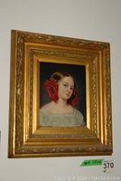 Framed art print showing full view including gold ornate frame and portrait of young woman with red ribbons.