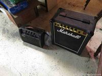 Marshall and Yamaha amplifiers side by side on floor