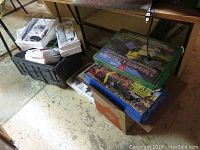 Two boxed PC model kits and assorted boxed items under a table
