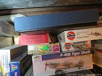 Stack of boxed model kits including Revell P-40B Tiger Shark, Airfix Blenheim IV and Frog Lysander