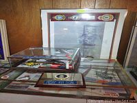 Wide view showing model airplane under glass, framed RCAF print behind and badges in display case