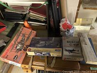 Four model airplane kits stacked on table including Sopwith Camel, HU-16B Albatross, Beech C-45F, and another partially visible kit.