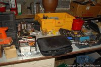 Photo of workbench with various tools including the boxed Winch Star Electric Winch, Black & Decker sander, yellow tool box, black carrying case and multiple hand tools scattered.