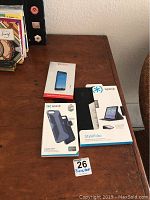 Photo showing three packaged Speck branded items on a wooden surface: iPhone screen protector, iPhone 7 Plus case, iPad StyleFolio case.