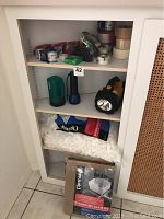 Shelf with various packing tapes, two flashlights, and popcorn packing material (foam peanuts)