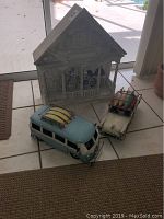 Metal house with bike designs and two metal vehicles, van and car