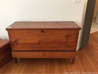 Full front view of vintage wooden chest showing front panel and drawer at base