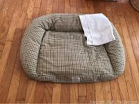 Orvis 38-inch medium dog bed with white blanket on hardwood floor