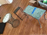 Three metal tables positioned on hardwood floor, showing all tables together including concrete top table, wire basket frame with glass top, and narrow faux copper table.