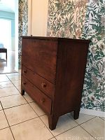 Side angle view showing the dresser's shape, height, and drawer layout